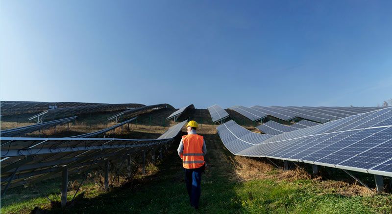 Dos instaladores de placas solares en un tejado realizando una instalación fotovoltaica